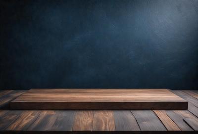 The primary subject of the image is a wooden table with a blue wall in the background. The table appears to be made of wood and has a brown color. The setting is a room with a blue wall, which creates a contrast with the wooden table. The visual style of the image is a photo, capturing the wooden table and the blue wall in a realistic manner. The colors and mood of the image are predominantly blue and brown, giving it a calm and natural atmosphere.