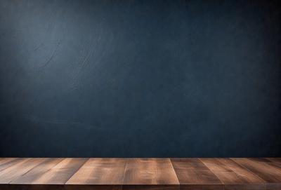 The primary subject of the image is a wooden table with a blue wall behind it. The table appears to be a wooden desk, and the blue wall adds a contrasting color to the scene. The visual style of the image is a photo, capturing the wooden desk and the blue wall in a realistic manner. The colors and mood of the image are predominantly blue, creating a calm and serene atmosphere.