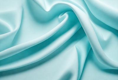The primary subject of the image is a blue fabric, which appears to be a piece of cloth or a curtain. The setting is a room with a blue background, which complements the blue fabric. The visual style is a close-up of the fabric, showcasing its texture and details. The colors and mood of the image are predominantly blue, creating a calm and serene atmosphere.