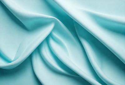 The primary subject of the image is a blue fabric, which is the main object, scene, or focus of the image. The setting or background is a blue cloth, and the visual style is a photo. The dominant colors and overall atmosphere are blue and serene.
