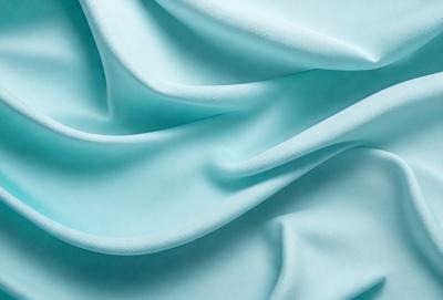 The primary subject of the image is a blue fabric, which appears to be a piece of cloth or a sheet. The setting is a close-up view of the fabric, showcasing its texture and color. The visual style is a realistic representation of the fabric, and the colors and mood are predominantly blue, creating a calm and soothing atmosphere.
