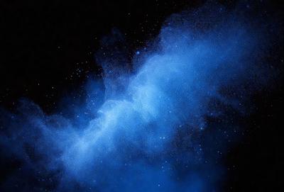The primary subject of the image is a blue, swirling, and cloudy space. The setting is a dark, starry sky, with the background featuring a multitude of stars. The visual style is a combination of a photo and digital art, creating a unique and captivating representation of the cosmos. The dominant colors are blue and black, giving the image a serene and mysterious atmosphere.
