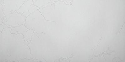 The primary subject of the image is a white wall with a cracked texture. The setting is a room with a white background. The visual style is a close-up of the wall, showcasing its unique texture. The colors and mood of the image are predominantly white, giving it a clean and minimalist appearance.