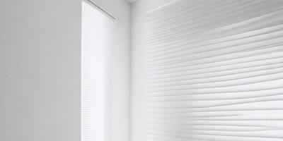 The primary subject of the image is a white shade or blind on a window. The setting is a white wall, and the visual style appears to be a photo. The colors and mood of the image are predominantly white, giving it a clean and minimalist appearance.