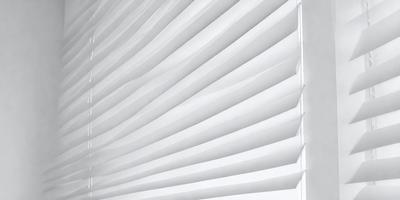 The primary subject of the image is a white curtain. The setting is a room with a white wall, and the visual style is a photo. The curtain is the main focus of the image, and the overall atmosphere is clean and minimalistic.
