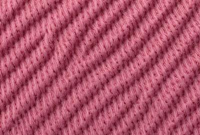 The primary subject of the image is a close-up of a pink and white striped fabric. The setting is a pink background, which creates a visually appealing contrast with the fabric. The visual style is a close-up of the fabric, showcasing its texture and pattern. The colors and mood of the image are predominantly pink and white, giving it a warm and inviting atmosphere.