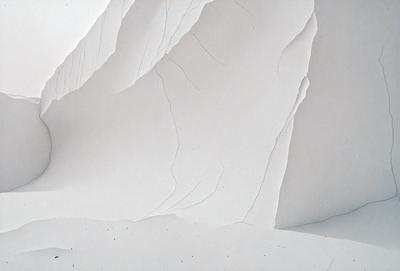 The primary subject of the image is a white paper with a hole in it. The paper is placed on a white surface, which could be a wall or a piece of paper. The visual style of the image is a close-up of the paper, showcasing its texture and the hole in it. The colors in the image are predominantly white, giving it a clean and minimalist appearance. The mood of the image is calm and simple, focusing on the paper and its hole as the main subject.