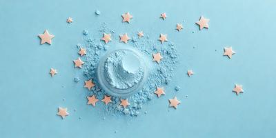 The primary subject of the image is a blue star-shaped object, which appears to be a cake or a decoration. The setting is a blue background, and the visual style is a close-up of the blue star-shaped object. The colors and mood of the image are predominantly blue, creating a calm and serene atmosphere.