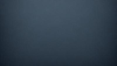 The primary subject of the image is a dark blue background. The setting is a void-like environment, with no visible objects or details. The visual style is a simple, monochromatic design. The colors and mood are predominantly dark and moody, with a hint of mystery.