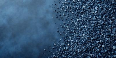 The primary subject of the image is a close-up of a blue surface with a pattern of small rocks. The setting appears to be a dark room, and the visual style is a close-up of the blue surface with the rocks. The dominant colors are blue and black, creating a moody atmosphere.