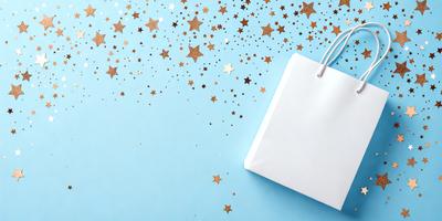 The primary subject of the image is a white shopping bag with gold stars on it. The bag is placed on a blue background, which adds a contrasting color to the scene. The visual style of the image is a combination of photo and digital art, creating a unique and eye-catching design. The overall atmosphere of the image is festive and celebratory, with the gold stars adding a touch of glamour and sophistication to the scene.