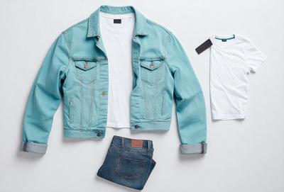 The primary subject of the image is a blue jacket, which is displayed on a white background. The jacket is accompanied by a pair of blue jeans, and a white shirt is also present in the scene. The overall atmosphere of the image is casual and relaxed, with the blue jacket and jeans suggesting a comfortable and laid-back style.