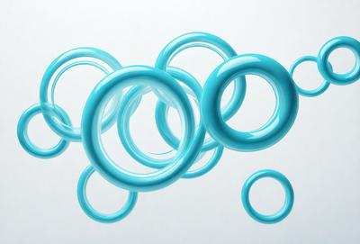 The primary subject of the image is a group of blue rings or circles floating in the air. The setting is a white background, which provides a clean and minimalistic environment for the rings. The visual style appears to be a digital art or illustration, as the rings are depicted in a way that resembles a water bubble or a soap bubble. The dominant colors are blue, which gives the image a calm and soothing atmosphere.