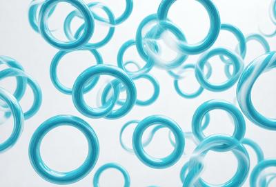 The primary subject of the image is a large number of blue rings or circles, which are floating in the air. The setting is a white background, which provides a clean and uncluttered environment for the rings to be displayed. The visual style of the image is a combination of photo and digital art, as the rings appear to be floating in a 3D space. The dominant colors in the image are blue, which gives the scene a calm and soothing atmosphere.