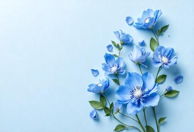 The primary subject of the image is a bouquet of blue flowers. The flowers are arranged in a vase, and they are placed against a blue wall. The visual style of the image is a close-up of the flowers, showcasing their beauty and details. The colors and mood of the image are predominantly blue, creating a calm and serene atmosphere.