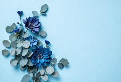 The primary subject of the image is a bouquet of blue flowers, including a blue flower with a green center, arranged in a vase. The setting is a blue wall, which serves as the backdrop for the flowers. The visual style is a close-up of the flowers, showcasing their beauty and details. The colors and mood of the image are predominantly blue, creating a calm and serene atmosphere.