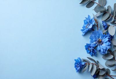 The primary subject of the image is a bouquet of blue flowers. The flowers are arranged in a vase, and they are placed on a blue surface, which could be a table or a wall. The visual style of the image is a close-up of the flowers, showcasing their beauty and details. The colors and mood of the image are predominantly blue, creating a calm and serene atmosphere.