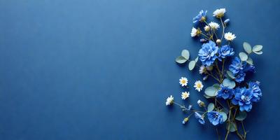 The primary subject of the image is a bouquet of white flowers with green leaves, arranged in a vase. The flowers are placed on a blue surface, which adds a contrasting and calming effect to the scene. The visual style of the image is a close-up of the flowers, showcasing their details and beauty. The colors and mood of the image are predominantly blue and white, creating a serene and peaceful atmosphere.