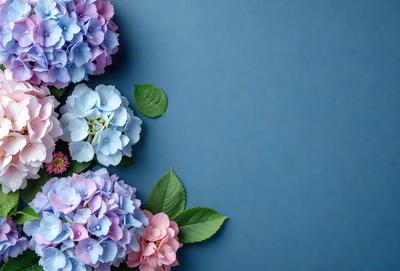 The primary subject of the image is a bouquet of purple and blue flowers. The flowers are arranged in a visually appealing manner, with some of them placed on a blue surface. The setting appears to be a studio or a controlled environment, as the flowers are displayed in a way that highlights their beauty. The visual style of the image is a close-up of the flowers, showcasing their details and colors. The dominant colors in the image are purple and blue, creating a serene and calming atmosphere.