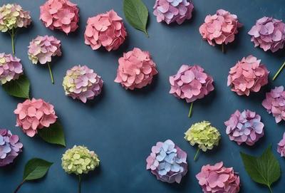 The primary subject of the image is a group of flowers, specifically pink and purple hibiscus flowers, arranged in a visually appealing manner. The flowers are placed on a blue background, which adds a contrasting and calming effect to the scene. The visual style of the image is a combination of photo and digital art, creating a realistic yet artistic representation of the flowers. The dominant colors in the image are pink and purple, which evoke a sense of warmth and tranquility.