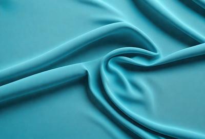The primary subject of the image is a blue fabric, which is the main object, scene, or focus of the image. The setting or background is a blue surface, which complements the blue fabric. The visual style of the image is a close-up of the blue fabric, showcasing its texture and details. The colors and mood of the image are predominantly blue, creating a calm and serene atmosphere.