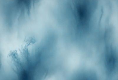 The primary subject of the image is a cloudy blue sky. The setting is a cloudy day, and the visual style is a natural, outdoor scene. The colors and mood of the image are predominantly blue, creating a calm and serene atmosphere.