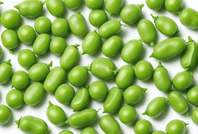 The primary subject of the image is a large group of green beans, which are the main objects in the scene. The beans are arranged in a pattern, covering the entire image. The setting is a white background, which provides a clean and uncluttered look to the image. The visual style is a close-up of the green beans, showcasing their texture and details. The colors and mood of the image are predominantly green, giving it a fresh and natural feel.