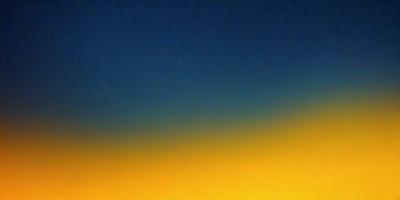 The primary subject of the image is a bright yellow sky with a blue background. The setting is a clear night sky, and the visual style appears to be a photo. The colors and mood of the image are vibrant and lively, with the yellow sky contrasting against the blue background.