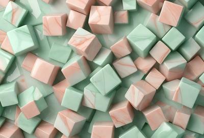 The primary subject of the image is a large pile of marbled, pink, and green colored cubes. The setting is a white surface, which provides a clean and contrasting background for the vibrant colors of the cubes. The visual style of the image is a close-up of the cubes, showcasing their unique marbled patterns. The colors and mood of the image are lively and cheerful, with the pink and green hues creating a sense of warmth and freshness.