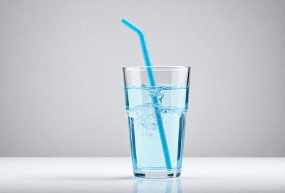 The primary subject of the image is a blue glass filled with water. The glass is placed on a white surface, which serves as the background. The visual style of the image is a photo, capturing the details of the glass and the water inside. The dominant colors in the image are blue and white, creating a calm and soothing atmosphere.
