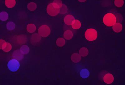 The primary subject of the image is a purple and red light show, with a purple background. The visual style appears to be a digital art or illustration, as the light show is depicted in a patterned manner. The colors and mood of the image are vibrant and energetic, creating a lively atmosphere.