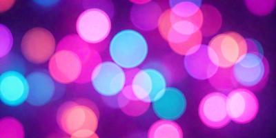 The primary subject of the image is a close-up of a colorful, pink and blue light display. The setting is a dark background, which contrasts with the bright and vibrant colors of the light display. The visual style of the image is a combination of a photo and digital art, creating a unique and eye-catching effect. The dominant colors in the image are pink and blue, giving the scene a lively and energetic atmosphere.