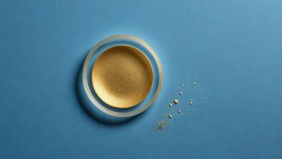 The primary subject of the image is a small, round, clear glass bowl filled with a yellow substance. The bowl is placed on a blue surface, which serves as the setting or background. The visual style of the image is a close-up of the bowl, showcasing the yellow substance inside. The colors and mood of the image are predominantly blue and yellow, creating a calm and inviting atmosphere.