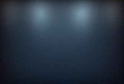 The primary subject of the image is a large, dark room with three lights on the ceiling. The setting is a black background, which creates a dramatic and moody atmosphere. The visual style is a photo, capturing the room's interior with the lights illuminating the space. The colors and mood are predominantly dark, with the lights providing a contrasting element to the overall ambiance.