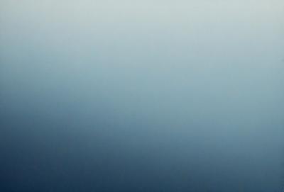 The primary subject of the image is a large, open, and cloudy sky. The setting is a vast, empty space with no visible landmarks or objects. The visual style is a natural, outdoor scene with a focus on the sky. The colors and mood of the image are predominantly blue, creating a calm and serene atmosphere.