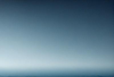 The primary subject of the image is a large, dark blue sky with no clouds. The setting is a vast, open space with no visible landmarks or objects. The visual style is a realistic representation of the sky, with no indication of digital manipulation or artistic elements. The colors and mood of the image are predominantly dark and moody, with the blue sky serving as the main focal point.