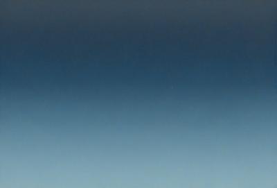 The primary subject of the image is the sky, which is a deep blue color. The setting is a cloudless day, with no visible clouds or other objects in the sky. The visual style of the image is a photo, capturing the beauty of the clear blue sky. The colors and mood of the image are serene and peaceful, as the sky is void of any disturbances or activity.