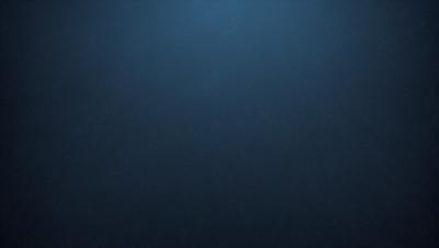 The primary subject of the image is a dark blue background with a few small white specks. The setting is a vast, open space with no visible objects or people. The visual style is a close-up of the dark blue background, which gives the image a moody and mysterious atmosphere.