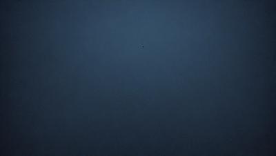 The primary subject of the image is a dark blue sky with a single star visible in the middle of the scene. The setting is a vast, open space with no other objects or elements in the background. The visual style is a simple, minimalist representation of the night sky. The colors and mood are predominantly dark and serene, with the star being the only point of light in the scene.