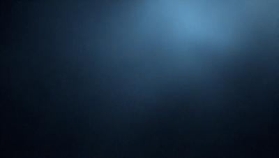 The primary subject of the image is a blue sky with a few clouds. The setting is a dark blue background, which creates a contrasting effect with the sky. The visual style is a photo, capturing the natural beauty of the sky. The colors and mood of the image are predominantly dark and moody, with the blue sky and clouds providing a sense of depth and tranquility.