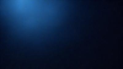 The primary subject of the image is a blue sky with a few clouds. The setting is a dark blue background, which creates a contrasting effect with the lighter blue sky. The visual style is a photo, capturing the natural beauty of the sky. The colors and mood of the image are predominantly dark and moody, with the blue sky and clouds providing a sense of depth and tranquility.