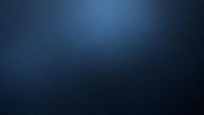 The primary subject of the image is a blue sky with no clouds. The setting is a dark blue background, which creates a contrast with the bright blue sky. The visual style is a photo, capturing the natural beauty of the sky. The colors and mood of the image are predominantly dark and moody, with the blue sky providing a sense of calmness and tranquility.