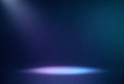 The primary subject of the image is a purple light, which is the main focus of the scene. The light is shining on a dark background, creating a dramatic and moody atmosphere. The visual style of the image is a photo, capturing the purple light and its surroundings. The colors and mood of the image are predominantly purple, with a hint of blue, giving it a mysterious and captivating appearance.