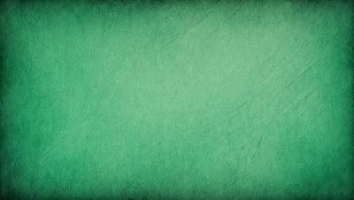 The primary subject of the image is a green background. The setting is a large, empty space with no visible objects or people. The visual style is a close-up of the green background, which appears to be a textured or patterned surface. The colors and mood of the image are predominantly green, creating a calm and serene atmosphere.