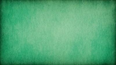 The primary subject of the image is a green background. The setting is a large, empty space with no visible objects or people. The visual style is a close-up of the green background, which appears to be a textured or patterned surface. The colors and mood of the image are predominantly green, creating a calm and serene atmosphere.