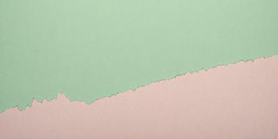 The primary subject of the image is a green and pink paper. The setting is a table, and the visual style is a close-up of the paper. The colors and mood of the image are predominantly green and pink, creating a vibrant and lively atmosphere.