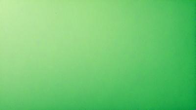 The primary subject of the image is a large, bright green wall. The setting is a plain, empty room with no other objects or people visible. The visual style is a close-up of the green wall, which gives a sense of depth and texture to the image. The colors and mood are predominantly green, creating a calm and serene atmosphere.