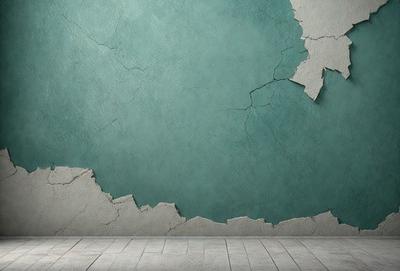 The primary subject of the image is a wall with a green color. The setting is a room with a wooden floor. The visual style is a photo, and the colors and mood are predominantly green, giving the scene a calm and serene atmosphere.