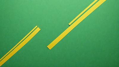 The primary subject of the image is a pair of yellow strips, which are placed on a green surface. The setting appears to be a table or a similar surface, with the green background providing a contrasting backdrop. The visual style of the image is a combination of photo and digital art, as it features a close-up view of the yellow strips. The colors and mood of the image are predominantly green and yellow, creating a warm and vibrant atmosphere.