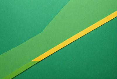 The primary subject of the image is a yellow and green striped paper, which is placed on a green background. The visual style of the image is a photo, and the colors and mood convey a sense of vibrancy and freshness.